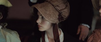 Movie still from “Becoming Jane” (2007), directed by Julian Jarrold – A young woman wearing a hat with a ribbon around her neck; Close Up shot, High angle