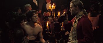 Movie still from “Becoming Jane” (2007), directed by Julian Jarrold – A man in a red jacket is drinking a bottle of wine; Medium shot, Over the shoulder angle