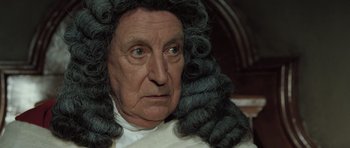 Movie still from “Becoming Jane” (2007), directed by Julian Jarrold – An old man wearing a wig and a white shirt; Close Up shot, Over the shoulder angle