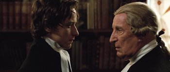 Movie still from “Becoming Jane” (2007), directed by Julian Jarrold – A man and a woman standing next to each other in a library; Close Up shot, Over the shoulder angle