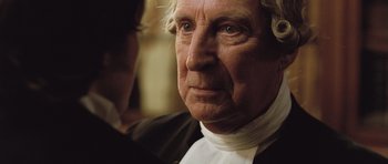 Movie still from “Becoming Jane” (2007), directed by Julian Jarrold – An older man with a white shirt and a white tie; Close Up shot, Over the shoulder angle