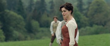 Movie still from “Becoming Jane” (2007), directed by Julian Jarrold – A young woman standing in front of two other people; Medium shot, Over the shoulder angle