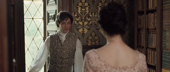 Movie still from “Becoming Jane” (2007), directed by Julian Jarrold – A man and a woman standing next to each other in front of a wall; Medium shot, Over the shoulder angle