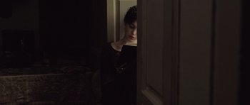 Movie still from “Becoming Jane” (2007), directed by Julian Jarrold – A woman looking at her cell phone in a dark room; Medium shot, High angle