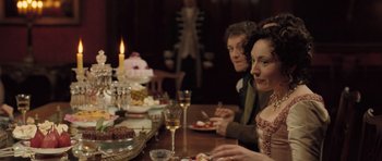 Movie still from “Becoming Jane” (2007), directed by Julian Jarrold – Two people sitting at a dinner table with a candle in the background; Medium shot, Over the shoulder angle