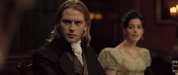 Movie still from “Becoming Jane” (2007), directed by Julian Jarrold – A man with long blonde hair wearing a suit and tie; Close Up shot, Over the shoulder angle