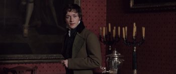 Movie still from “Becoming Jane” (2007), directed by Julian Jarrold – A young man in a green coat standing next to a silver urn; Medium shot, Over the shoulder angle