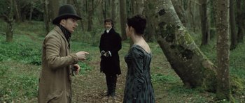Movie still from “Becoming Jane” (2007), directed by Julian Jarrold – A man and a woman are talking to another man in the woods; Medium shot, Over the shoulder angle