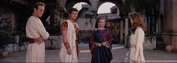 Movie still from “Ben-Hur” (1959), directed by William Wyler – A man and a woman dressed in roman garb standing next to each other in front of an archway; Medium shot, High angle