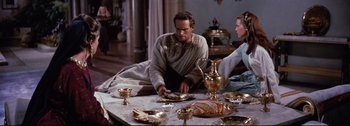 Movie still from “Ben-Hur” (1959), directed by William Wyler – A man sitting at a table with a plate of food; Medium shot, High angle