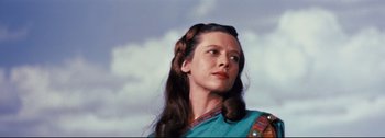 Movie still from “Ben-Hur” (1959), directed by William Wyler – A woman with long brown hair wearing a blue dress; Close Up shot, Low angle