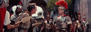 Movie still from “Ben-Hur” (1959), directed by William Wyler – A group of men dressed as roman legionnaires talking; Medium shot, Over the shoulder angle