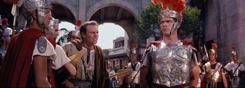 Movie still from “Ben-Hur” (1959), directed by William Wyler – A group of men standing next to each other in costumes; Medium shot, Over the shoulder angle
