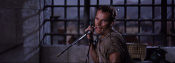 Movie still from “Ben-Hur” (1959), directed by William Wyler – A man holding a microphone in his hands; Close Up shot, High angle
