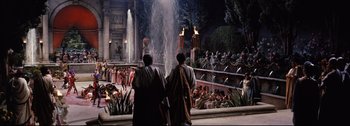 Movie still from “Ben-Hur” (1959), directed by William Wyler – Two men in ancient roman garb looking out at a fountain; Extreme Wide shot, High angle