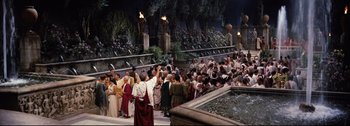 Movie still from “Ben-Hur” (1959), directed by William Wyler – A group of people standing around a fountain with torches; Extreme Wide shot, High angle