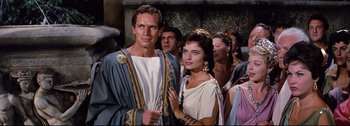 Movie still from “Ben-Hur” (1959), directed by William Wyler – A man and a woman standing next to each other; Medium shot, Over the shoulder angle