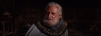 Movie still from “Ben-Hur” (1959), directed by William Wyler – An old man with a beard wearing a gold necklace; Close Up shot, Low angle