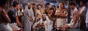 Movie still from “Ben-Hur” (1959), directed by William Wyler – A group of men standing around a man in a crown; Medium shot, High angle