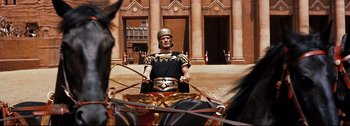 Movie still from “Ben-Hur” (1959), directed by William Wyler – A man in a roman soldier costume riding a horse and carriage; Wide shot, Low angle
