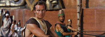 Movie still from “Ben-Hur” (1959), directed by William Wyler – Two men in ancient roman garb are posing for a picture; Medium shot, Over the shoulder angle