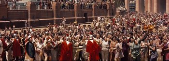 Movie still from “Ben-Hur” (1959), directed by William Wyler – A large crowd of people are gathered in a stadium to watch a performance of julius caesar; Extreme Wide shot, High angle