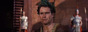 Movie still from “Ben-Hur” (1959), directed by William Wyler – A person wearing a wreath of leaves on their head; Close Up shot, Over the shoulder angle