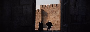 Movie still from “Ben-Hur” (1959), directed by William Wyler – Two people are standing in front of a stone wall; Extreme Wide shot, Low angle