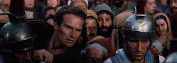 Movie still from “Ben-Hur” (1959), directed by William Wyler – A group of men standing next to each other in a crowd; Close Up shot, Low angle