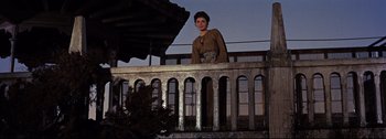 Movie still from “Ben-Hur” (1959), directed by William Wyler – A woman standing on top of an iron railing at night; Wide shot, Low angle