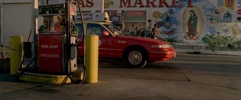 Movie still from “Collateral” (2004), directed by Michael Mann – A red car parked in front of a gas station; Wide shot, High angle