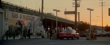 Movie still from “Collateral” (2004), directed by Michael Mann – A man standing in front of a red taxi cab; Extreme Wide shot, Low angle