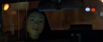 Movie still from “Collateral” (2004), directed by Michael Mann – A woman sitting in the back seat of a car at night; Close Up shot, Over the shoulder angle