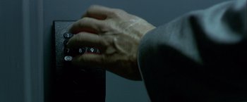 Movie still from “Collateral” (2004), directed by Michael Mann – A hand is holding the number 9 on a calculator; Extreme Close Up shot, Overhead angle