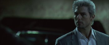 Movie still from “Collateral” (2004), directed by Michael Mann – A person wearing a suit and tie; Close Up shot, Low angle