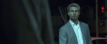 Movie still from “Collateral” (2004), directed by Michael Mann – A man in a suit and tie looking to his left; Close Up shot, Over the shoulder angle
