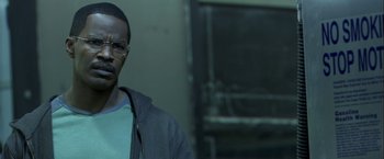 Movie still from “Collateral” (2004), directed by Michael Mann – A man with glasses is standing in front of a door; Close Up shot, Over the shoulder angle