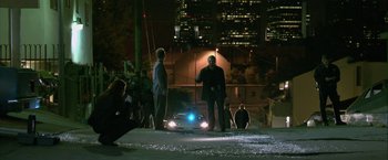 Movie still from “Collateral” (2004), directed by Michael Mann – Two men standing on the side of the road at night; Wide shot, High angle