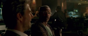 Movie still from “Collateral” (2004), directed by Michael Mann – A person wearing glasses in a room; Close Up shot, Over the shoulder angle