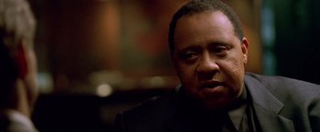 Movie still from “Collateral” (2004), directed by Michael Mann – A person wearing a suit and tie; Close Up shot, Low angle