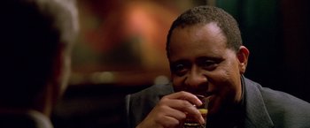 Movie still from “Collateral” (2004), directed by Michael Mann – A man holding a glass in his hand; Close Up shot, Over the shoulder angle