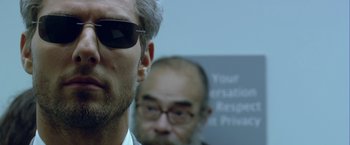 Movie still from “Collateral” (2004), directed by Michael Mann – A person wearing a pair of sunglasses; Close Up shot, Over the shoulder angle