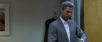 Movie still from “Collateral” (2004), directed by Michael Mann – A man in a suit and tie in front of a wall; Close Up shot, Over the shoulder angle