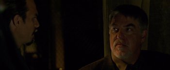 Movie still from “Collateral” (2004), directed by Michael Mann – A person in a dark room; Close Up shot, Over the shoulder angle