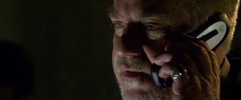 Movie still from “Collateral” (2004), directed by Michael Mann – An older man talking on a cell phone in the dark; Close Up shot, Low angle