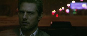 Movie still from “Collateral” (2004), directed by Michael Mann – A person in a dark room; Close Up shot, Over the shoulder angle