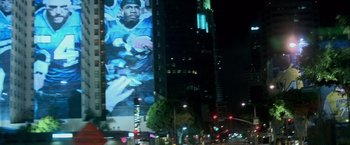 Movie still from “Collateral” (2004), directed by Michael Mann – A large poster of a football player on the side of a tall building; Extreme Wide shot, Low angle