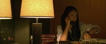Movie still from “Collateral” (2004), directed by Michael Mann – A woman sitting at a desk talking on a phone; Medium shot, High angle