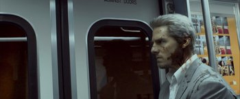 Movie still from “Collateral” (2004), directed by Michael Mann – A man in a suit looking into a train window; Close Up shot, Over the shoulder angle