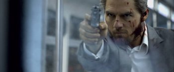 Movie still from “Collateral” (2004), directed by Michael Mann – A person holding a gun in a room; Close Up shot, Over the shoulder angle